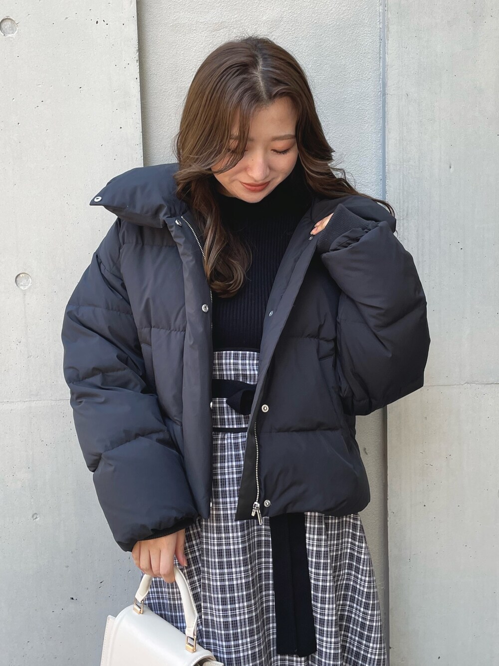 ブラック系のブーツ、ブラック系のワンピース、ブラック系のダウンジャケット/コートを着用したレディースの冬コーディネートの3枚目の写真