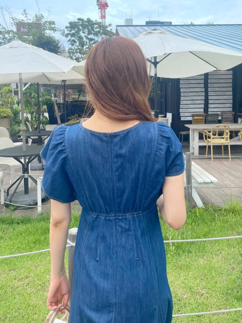 ホワイト系のハンドバッグ、ホワイト系のサンダル、ブルー系のワンピースを着用したレディースの夏コーディネートの6枚目の写真