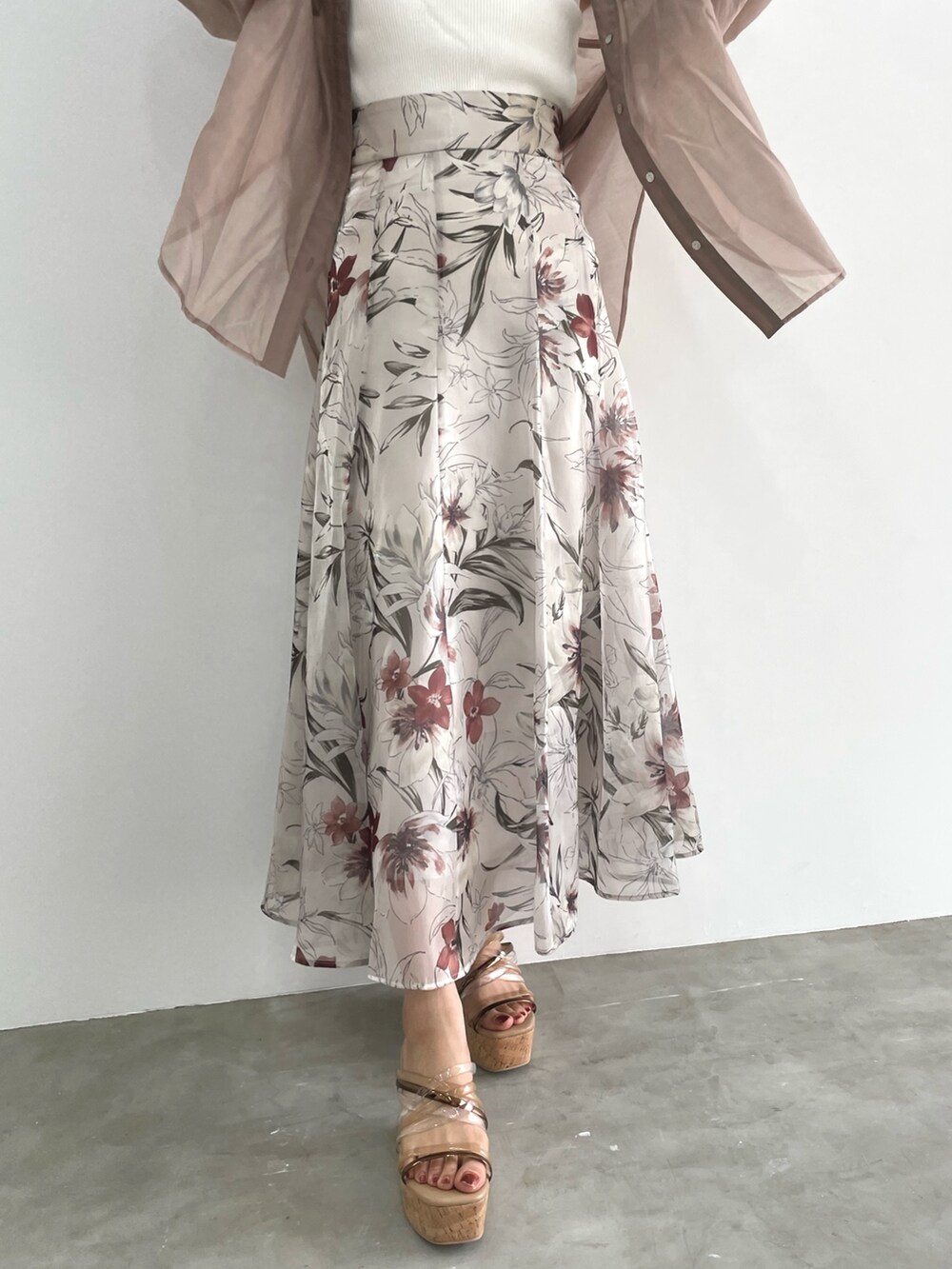 ピンク系のスカート、ホワイト系のニット/セーター、ベージュ系のシャツ/ブラウスを着用したレディースの春コーディネートの5枚目の写真