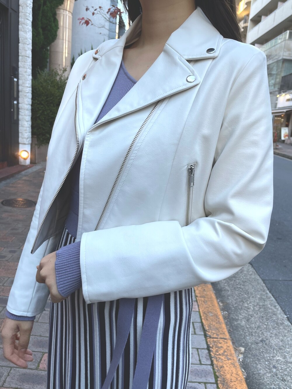 パープル系のワンピース、ホワイト系のライダースジャケットを着用したレディースの冬コーディネートの8枚目の写真