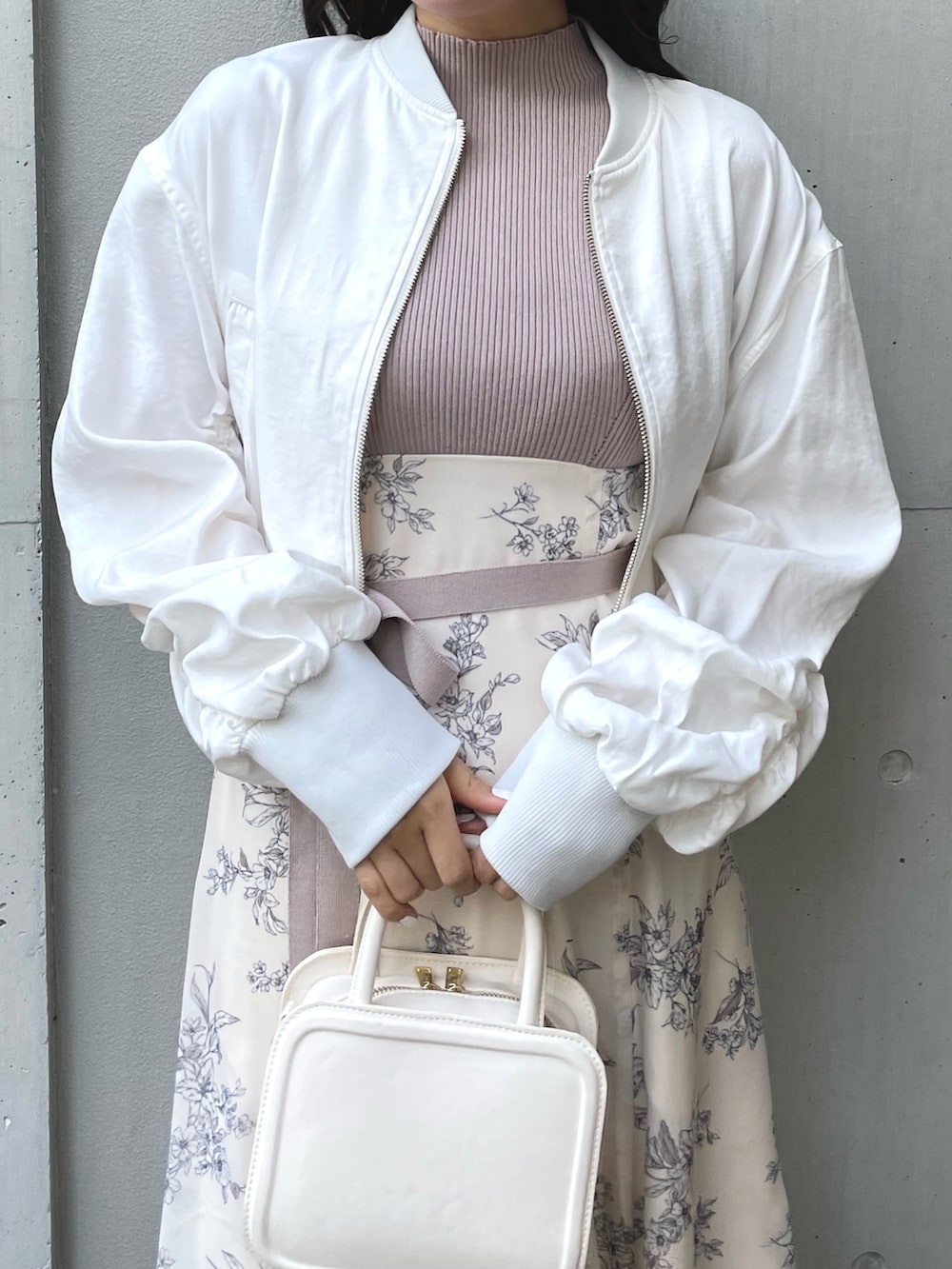 ブラック系のブーツ、ブラック系のハンドバッグ、ホワイト系のワンピースを着用したレディースの春コーディネートの6枚目の写真