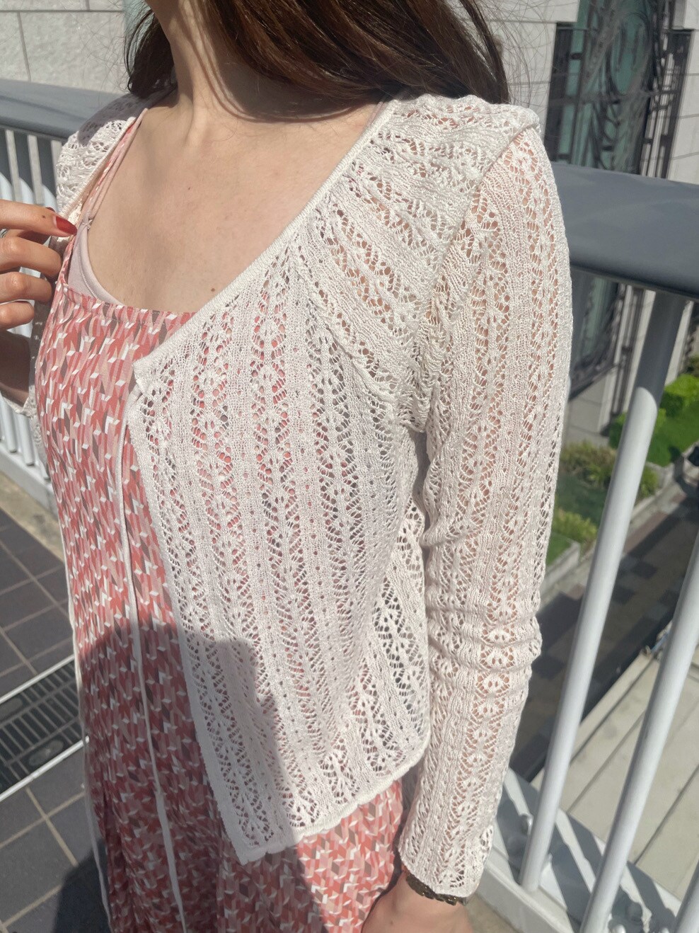 シルバー系のサンダル、オレンジ系のワンピース、ホワイト系のニット/セーターを着用したレディースの春コーディネートの4枚目の写真