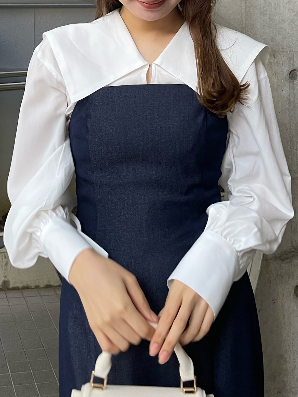 ブルー系のワンピース、ホワイト系のブーツを着用したレディースの冬コーディネートの2枚目の写真