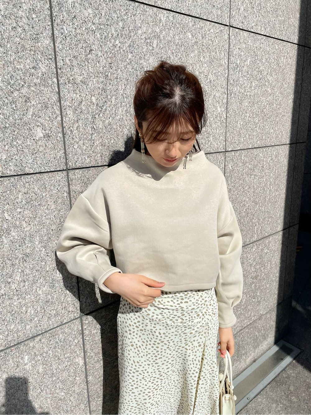 その他のスカート、ホワイト系のハンドバッグ、ホワイト系のブーツを着用したレディースの冬コーディネートの4枚目の写真