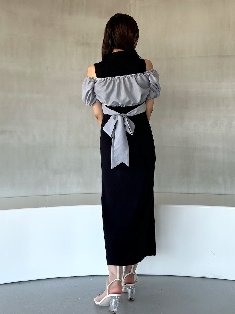 ブルー系のワンピース、ホワイト系のハンドバッグ、ホワイト系のブーツを着用したレディースの冬コーディネートの4枚目の写真