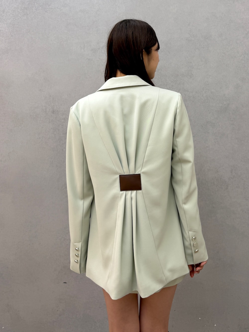 グリーン系のテーラードジャケット、ホワイト系のシャツ/ブラウス、グリーン系のスカートを着用したレディースの冬コーディネートの4枚目の写真