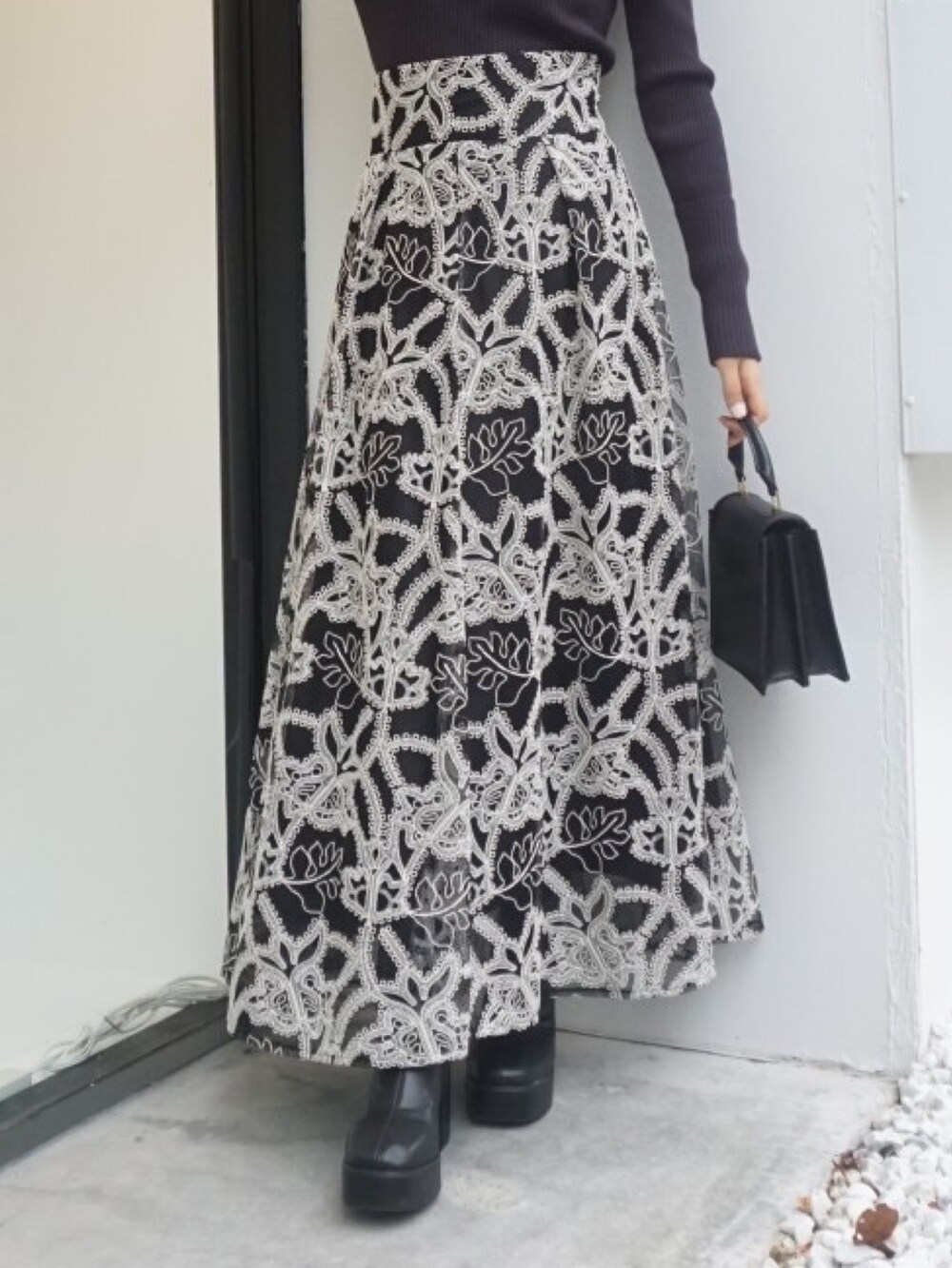 ブラック系のブーツ、ブラック系のスカート、グレー系のニット/セーターを着用したレディースの冬コーディネートの5枚目の写真