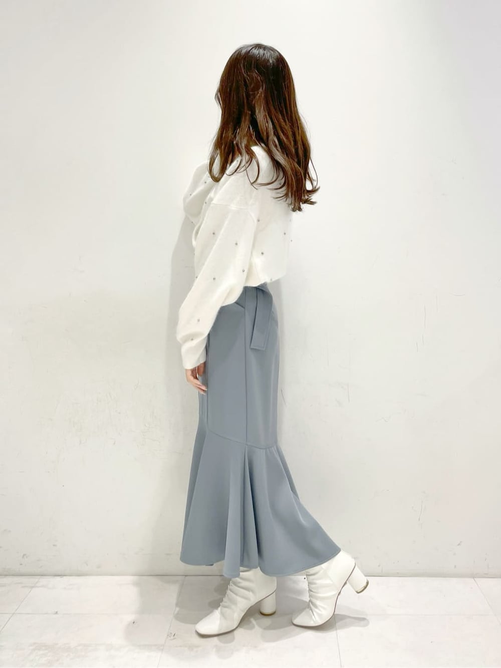 ホワイト系のその他シューズ、ブルー系のスカート、ホワイト系のカーディガン/ボレロを着用したレディースの冬コーディネートの2枚目の写真