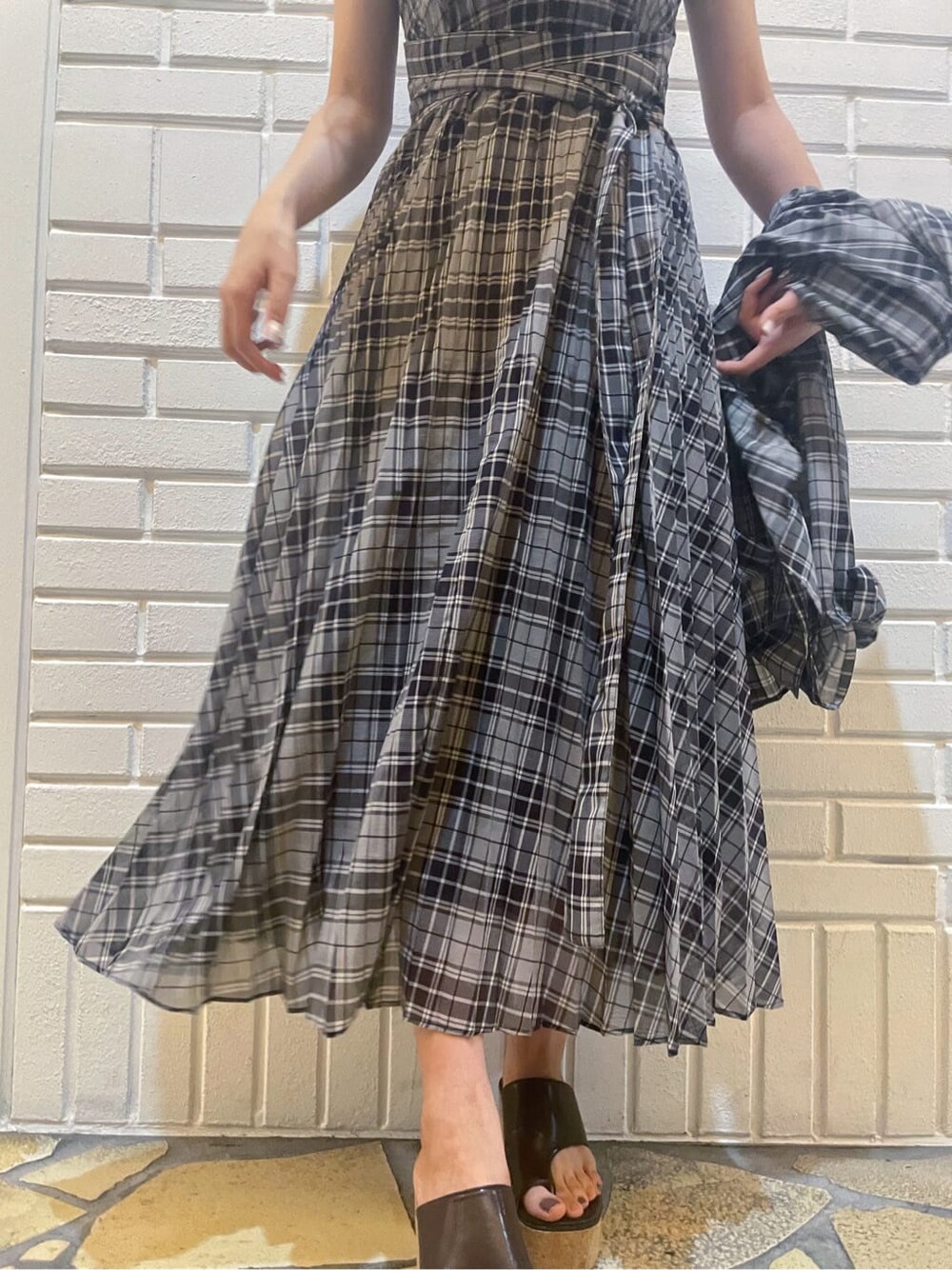 ブラック系のワンピース、ブラック系のシャツ/ブラウス、ブラウン系のサンダルを着用したレディースの夏コーディネートの9枚目の写真