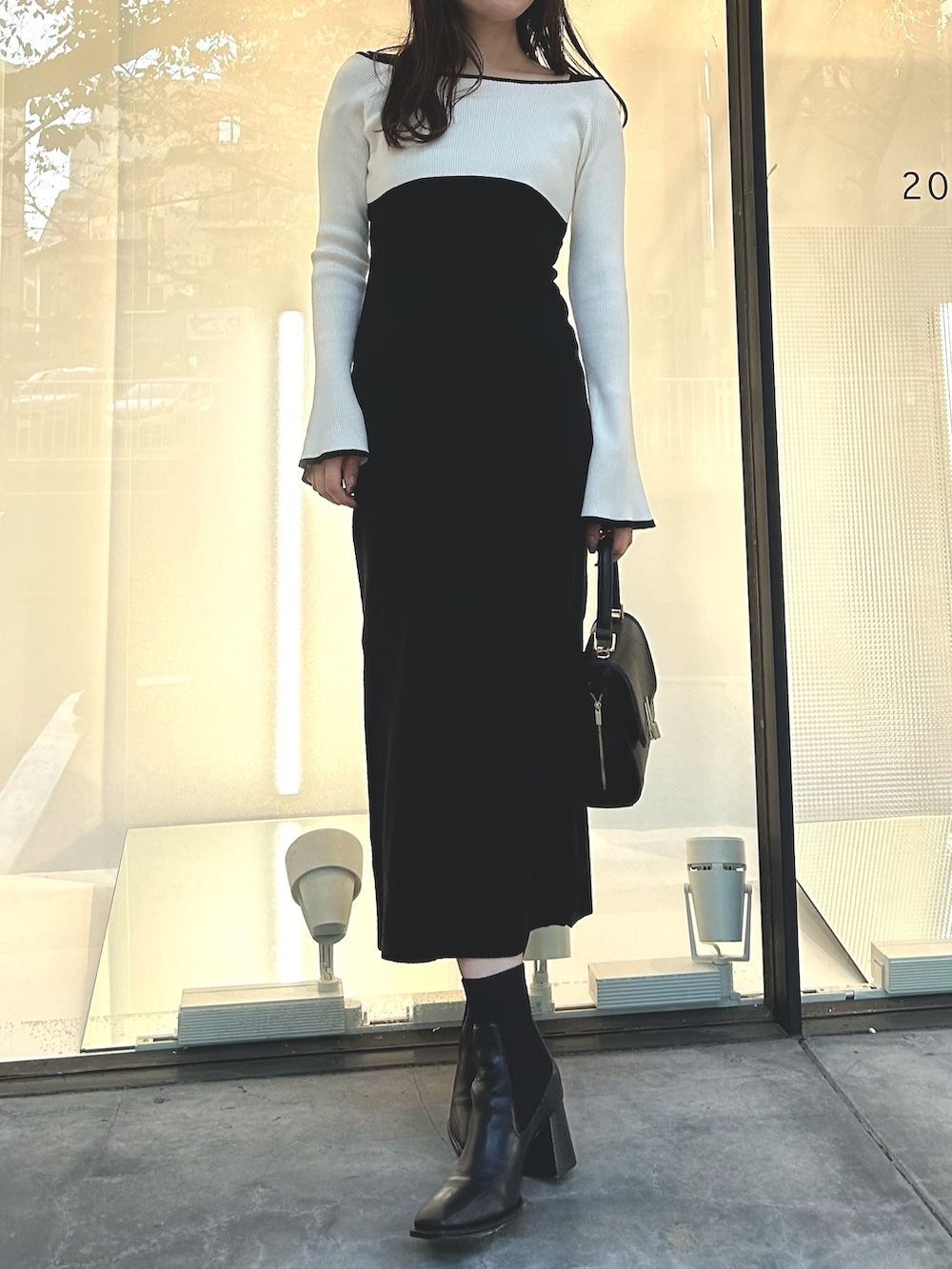 ブラック系のワンピース、ブラック系のショルダーバッグ、ブラック系のブーツを着用したレディースの秋コーディネートの2枚目の写真