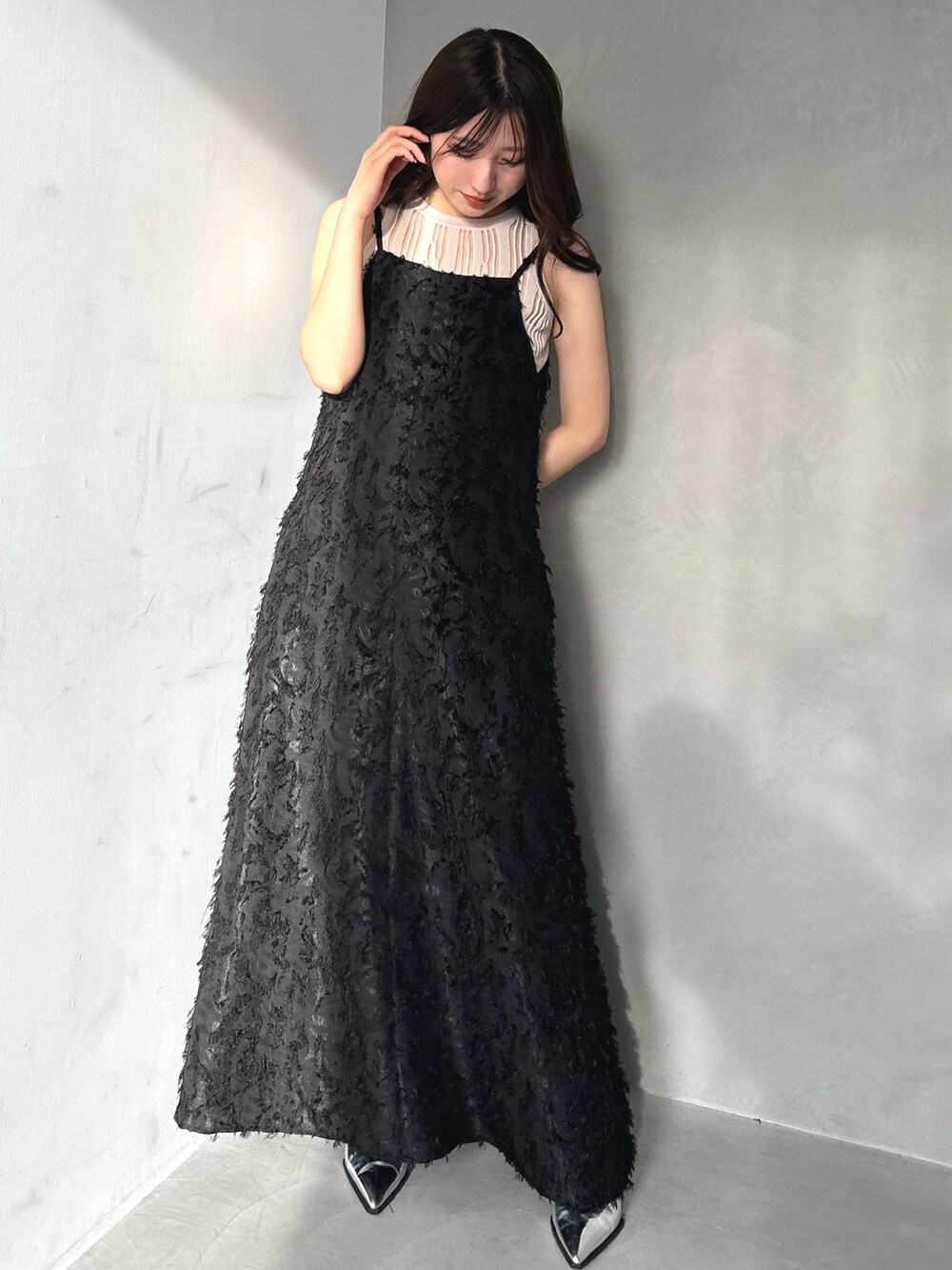 ベージュ系のニット/セーター、ブラック系のワンピースを着用したレディースの春コーディネートの2枚目の写真