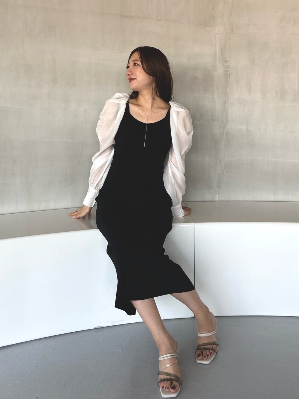 ブラック系のワンピース、ホワイト系のサンダルを着用したレディースの冬コーディネートの6枚目の写真