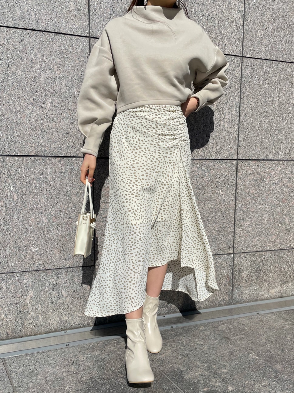 その他のスカート、ホワイト系のハンドバッグ、ホワイト系のブーツを着用したレディースの冬コーディネートの5枚目の写真