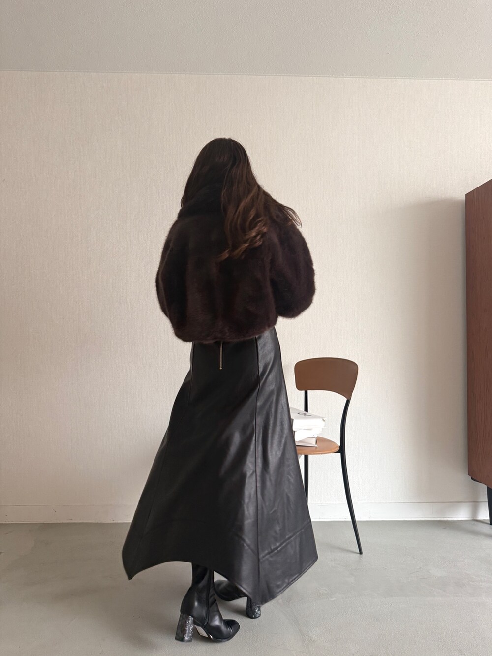 ブルー系のニット/セーター、ブラウン系のその他アウター、ブラック系のスカートを着用したレディースの秋コーディネートの3枚目の写真