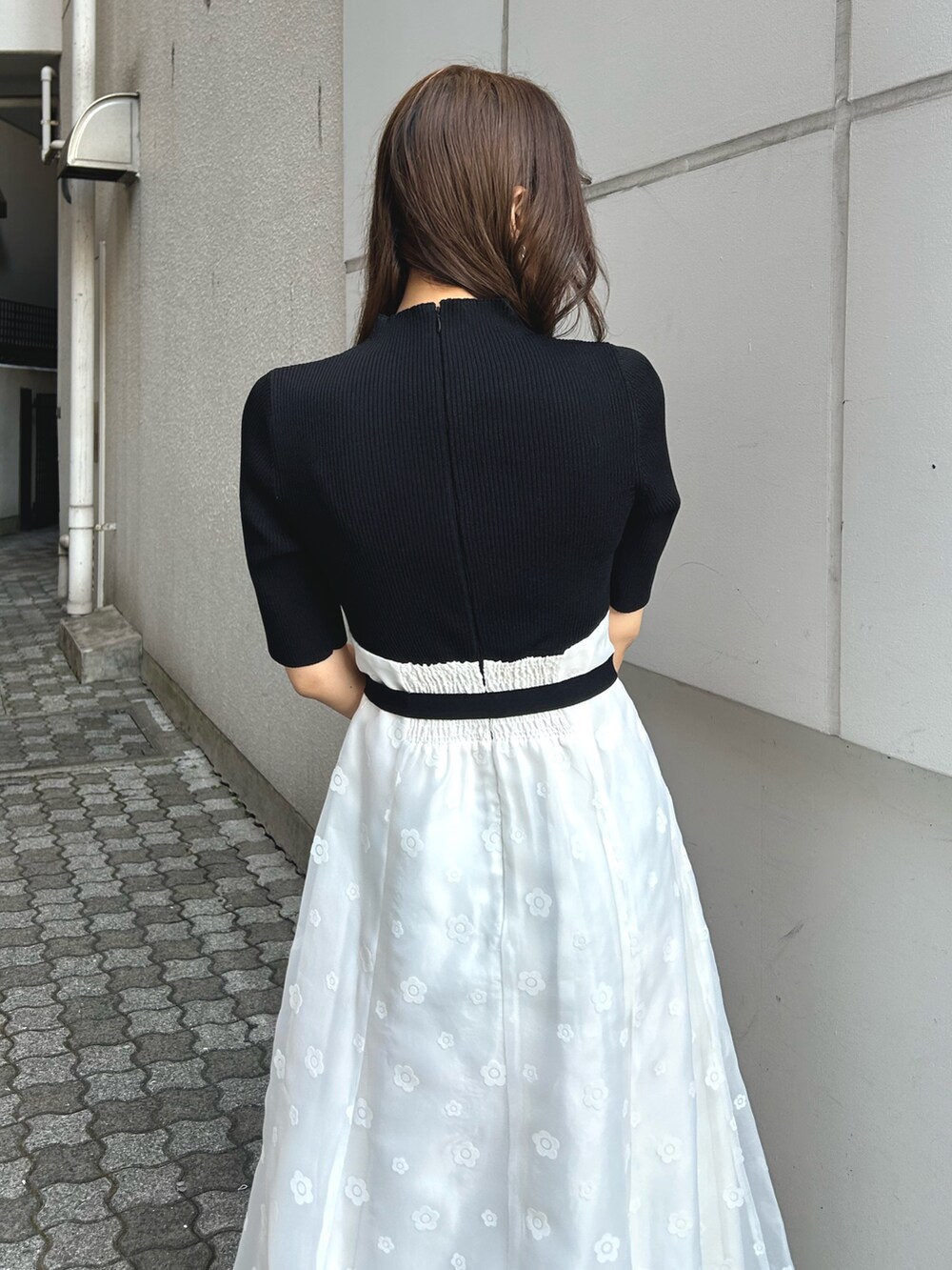 ブラック系のワンピース、ホワイト系のパンプス、パープル系のトレンチコートを着用したレディースの冬コーディネートの5枚目の写真