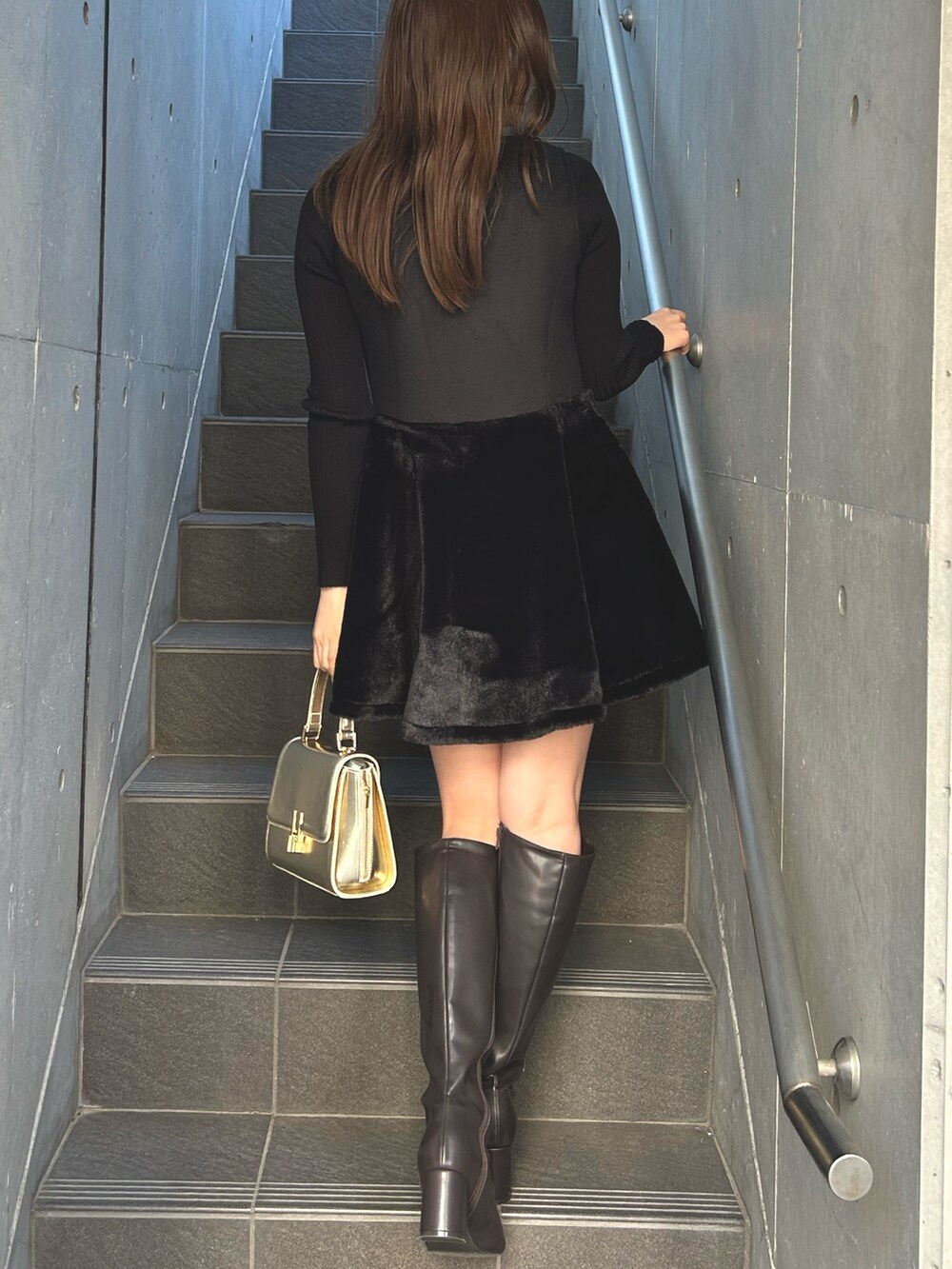 ブラック系のワンピース、レッド系のスカート、ブラウン系のブーツを着用したレディースの秋コーディネートの2枚目の写真