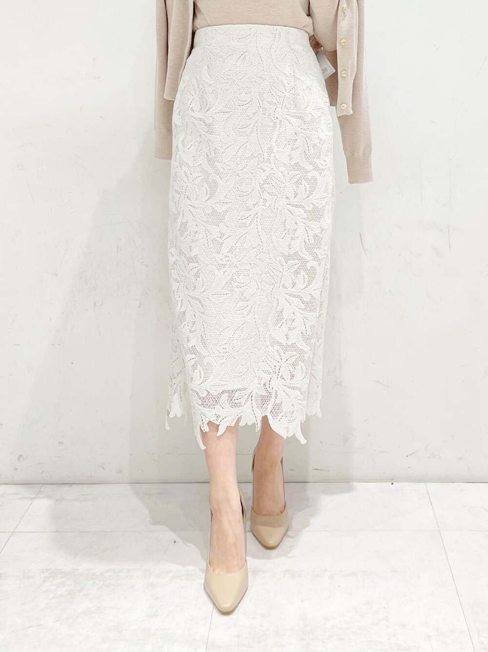 ベージュ系のパンプス、ベージュ系のニット/セーター、ホワイト系のスカートを着用したレディースの冬コーディネートの4枚目の写真