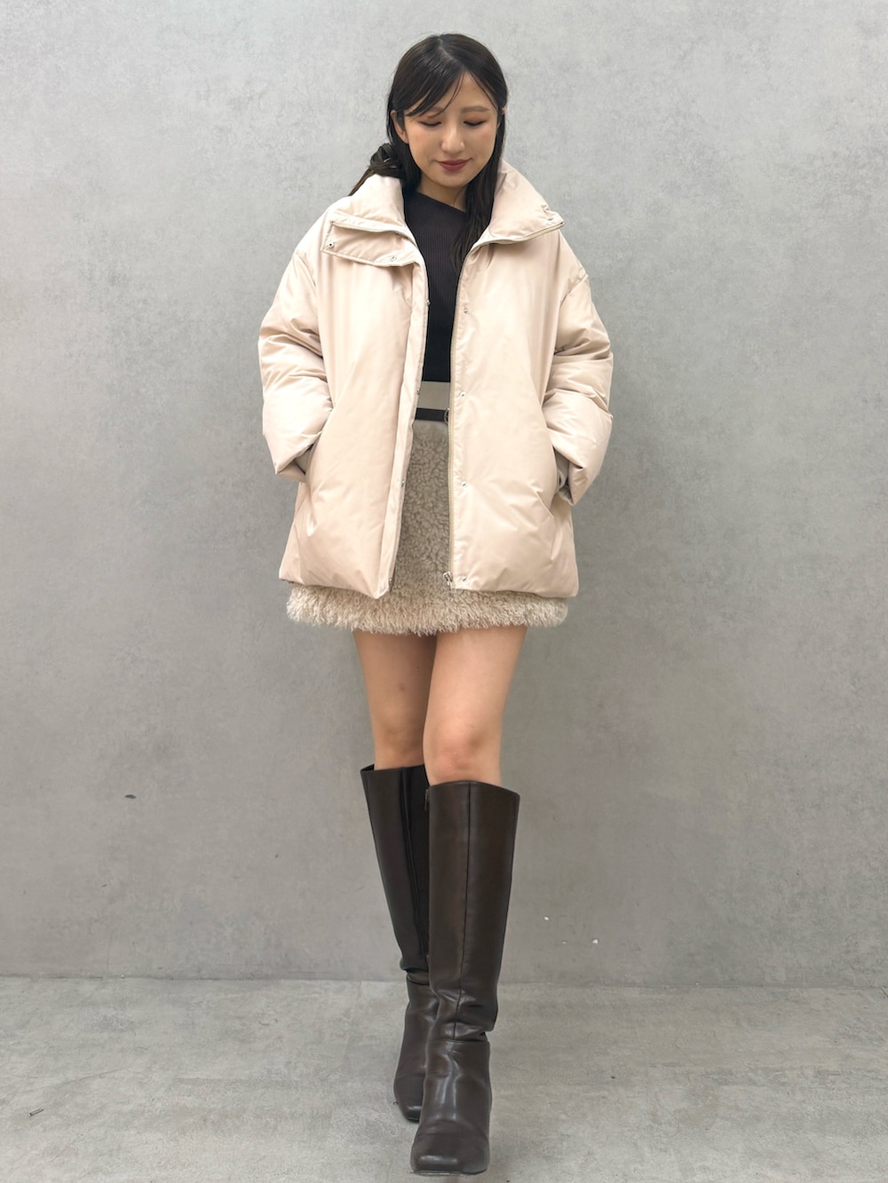 ピンク系のダウンジャケット/コート、ホワイト系のスカート、ブラウン系のブーツを着用したレディースの秋コーディネートの4枚目の写真