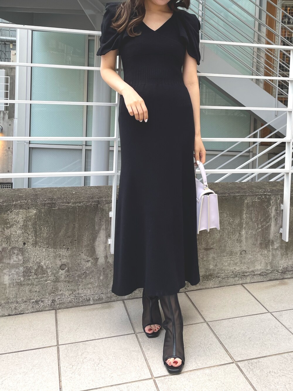 ピンク系のトレンチコート、グレー系のワンピース、パープル系のハンドバッグを着用したレディースの春コーディネートの4枚目の写真