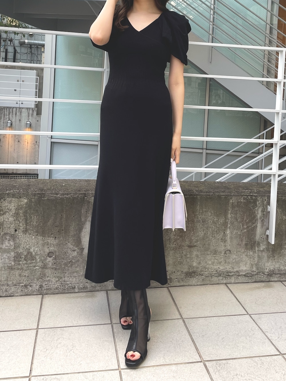 ピンク系のトレンチコート、グレー系のワンピース、パープル系のハンドバッグを着用したレディースの春コーディネートの3枚目の写真