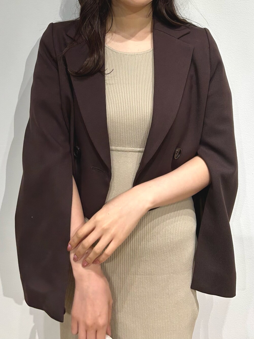 ブラウン系のテーラードジャケット、ベージュ系のワンピース、ホワイト系のブーツを着用したレディースの夏コーディネートの4枚目の写真