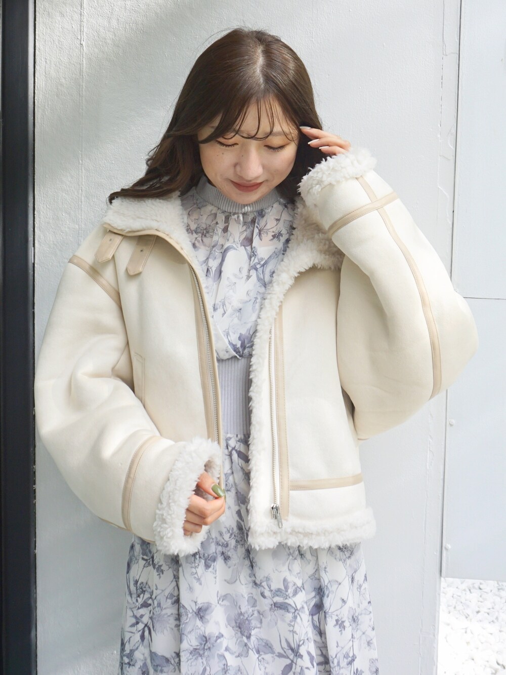 ブラック系のブーツ、ホワイト系のムートンコート、グレー系のワンピースを着用したレディースの冬コーディネートの6枚目の写真