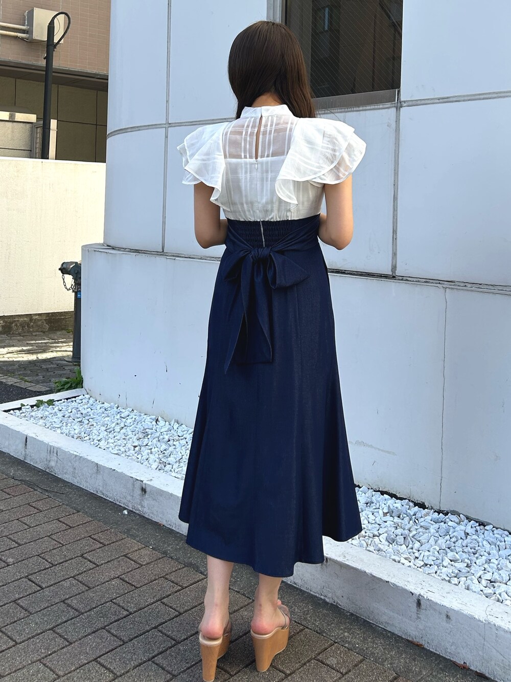 ホワイト系のワンピース、グレー系のサンダルを着用したレディースの春コーディネートの3枚目の写真