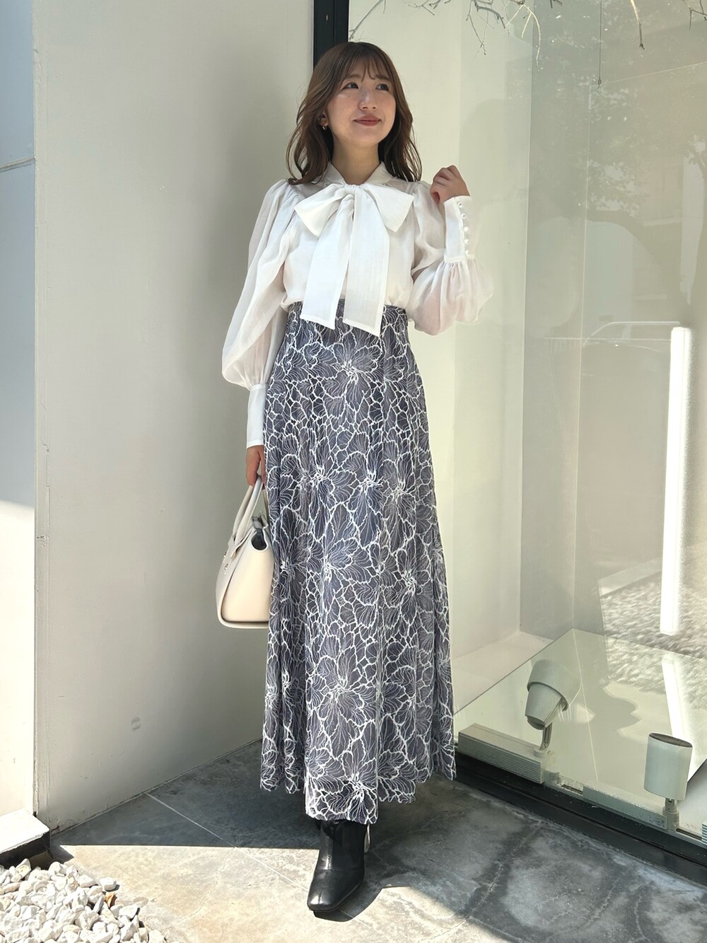 ブラック系のライダースジャケット、ホワイト系のシャツ/ブラウス、ブルー系のスカートを着用したレディースの夏コーディネートの4枚目の写真