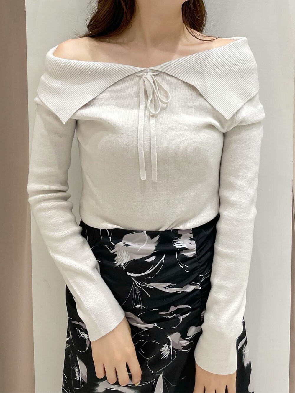 ブラック系のその他シューズ、ホワイト系のニット/セーター、ブラック系のスカートを着用したレディースの秋コーディネートの6枚目の写真