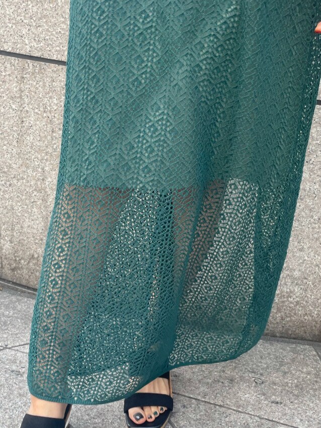 グリーン系のワンピース、ブラック系のサンダルを着用したレディースの春コーディネートの6枚目の写真