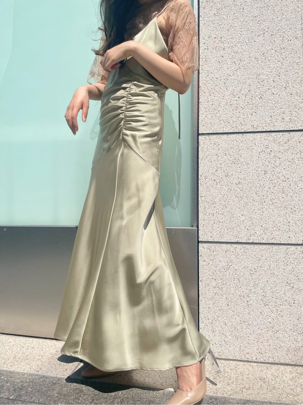 グリーン系のドレス、ベージュ系のパンプスを着用したレディースの夏コーディネートの3枚目の写真