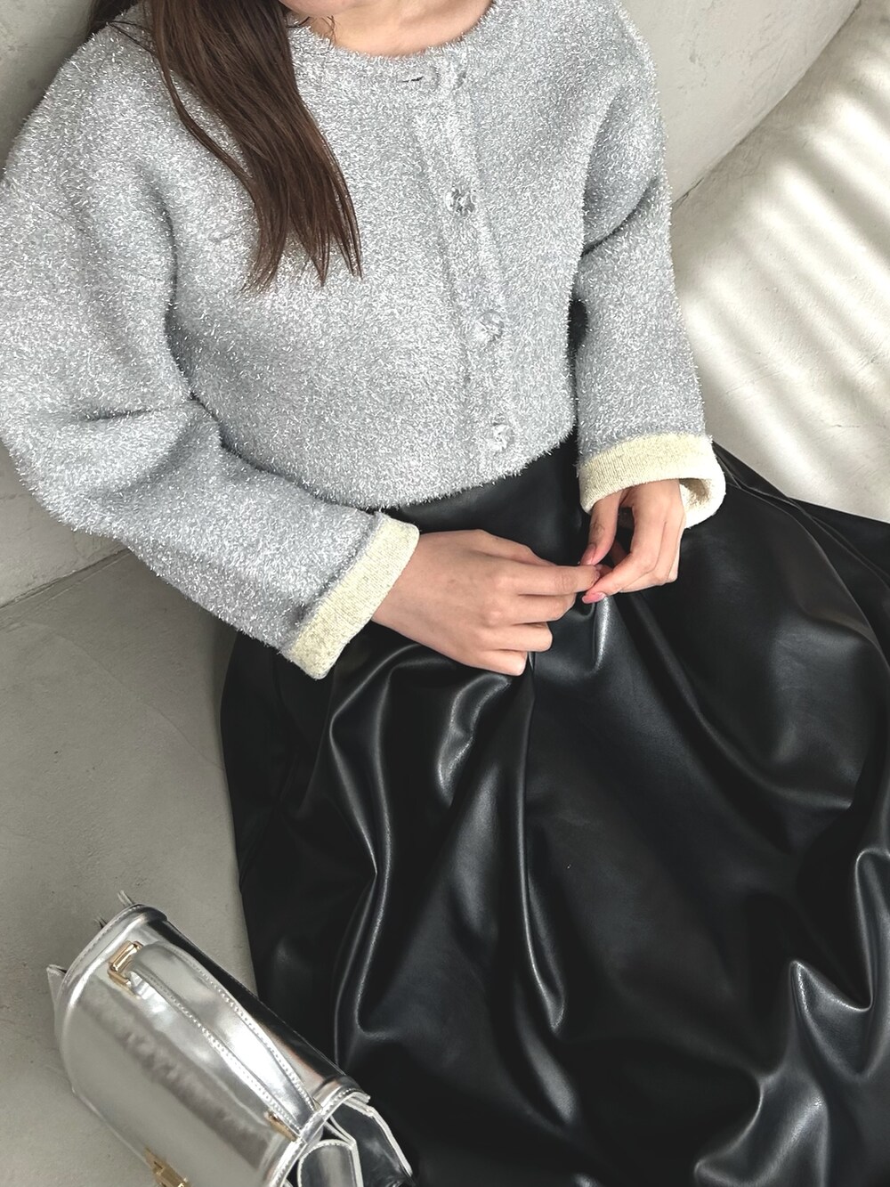 シルバー系のカーディガン/ボレロ、ブラック系のスカート、ブラック系のローファーを着用したレディースの冬コーディネートの4枚目の写真