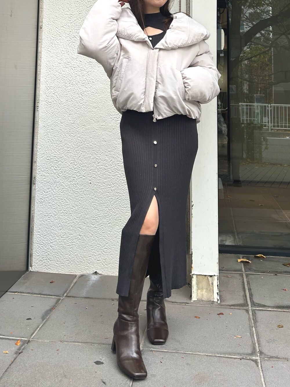 ブラウン系のブーツ、ピンク系のダウンジャケット/コート、グレー系のワンピースを着用したレディースの冬コーディネートの7枚目の写真