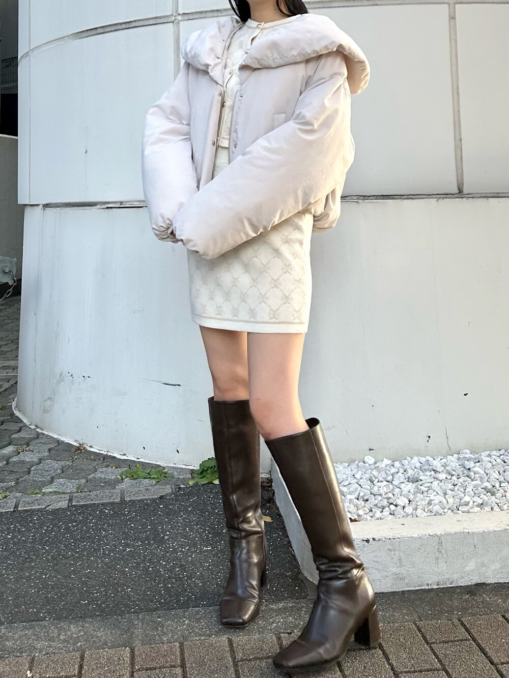 ホワイト系のワンピース、ホワイト系のダウンジャケット/コート、ブラウン系のブーツを着用したレディースの冬コーディネートの2枚目の写真