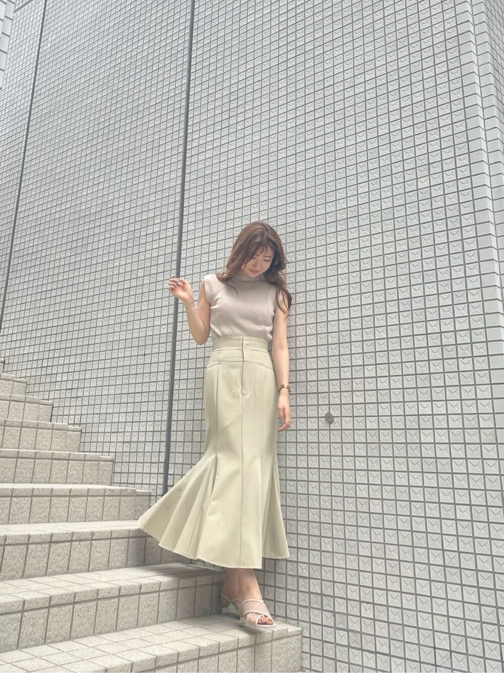 ベージュ系のニット/セーター、ベージュ系のサンダルを着用したレディースの夏コーディネートの2枚目の写真