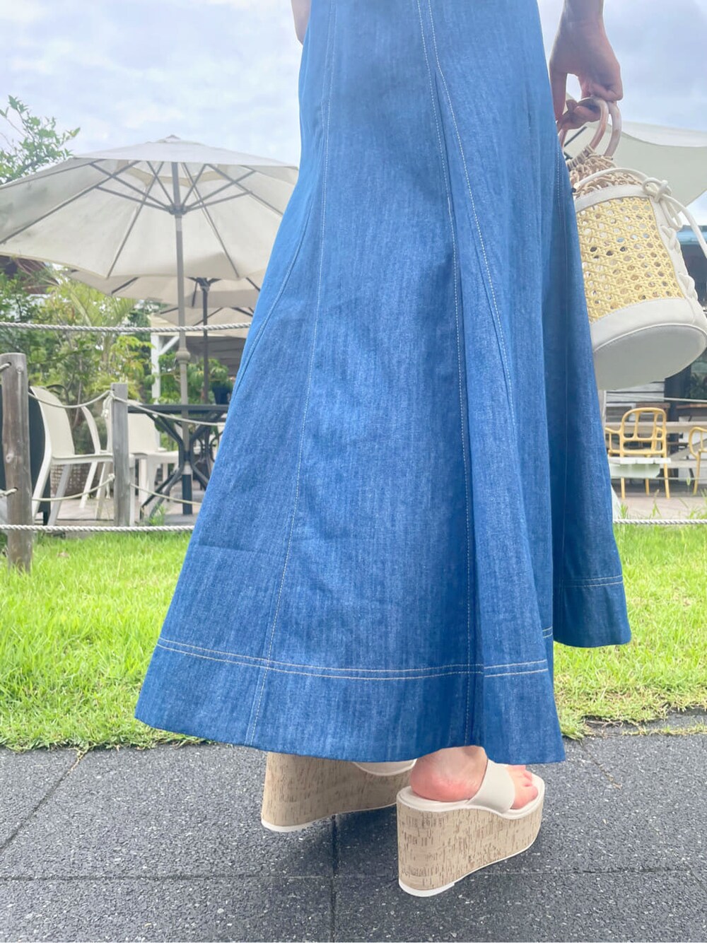 ホワイト系のハンドバッグ、ホワイト系のサンダル、ブルー系のワンピースを着用したレディースの夏コーディネートの10枚目の写真