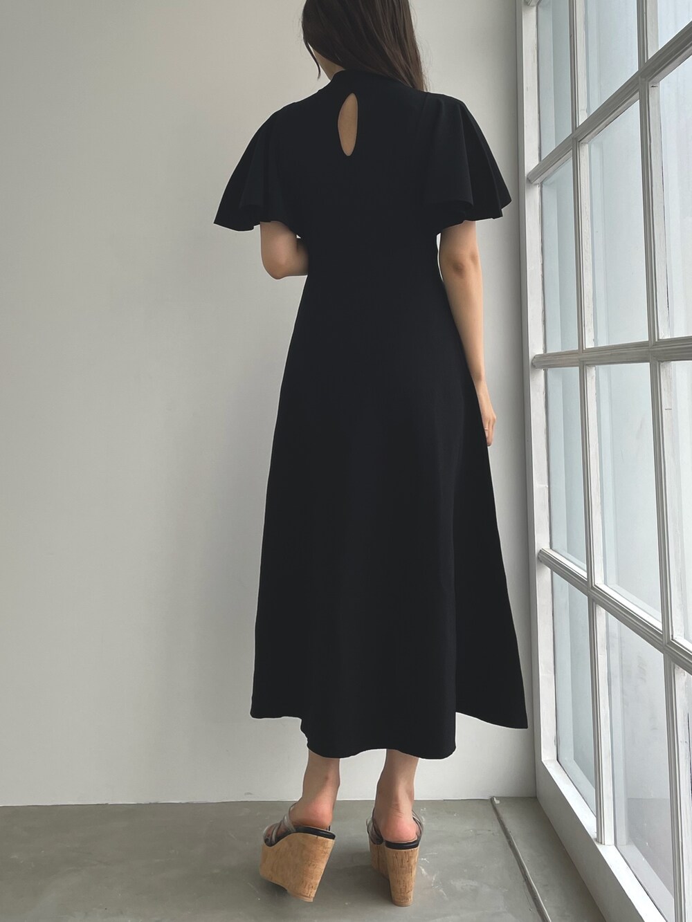 ブラック系のサンダル、ブラック系のワンピースを着用したレディースの春コーディネートの2枚目の写真