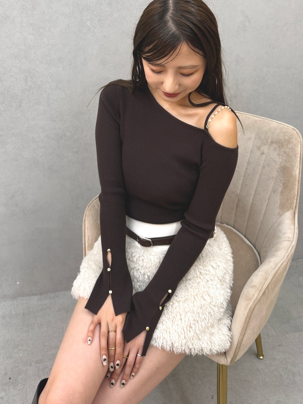 ブラウン系のニット/セーター、ホワイト系のスカート、ブラウン系のブーツを着用したレディースの秋コーディネートの4枚目の写真