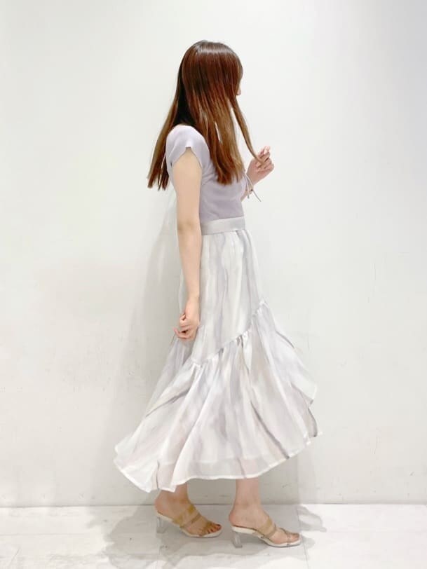 ピンク系のスカート、ベージュ系のサンダル、パープル系のニット/セーターを着用したレディースの春コーディネートの3枚目の写真