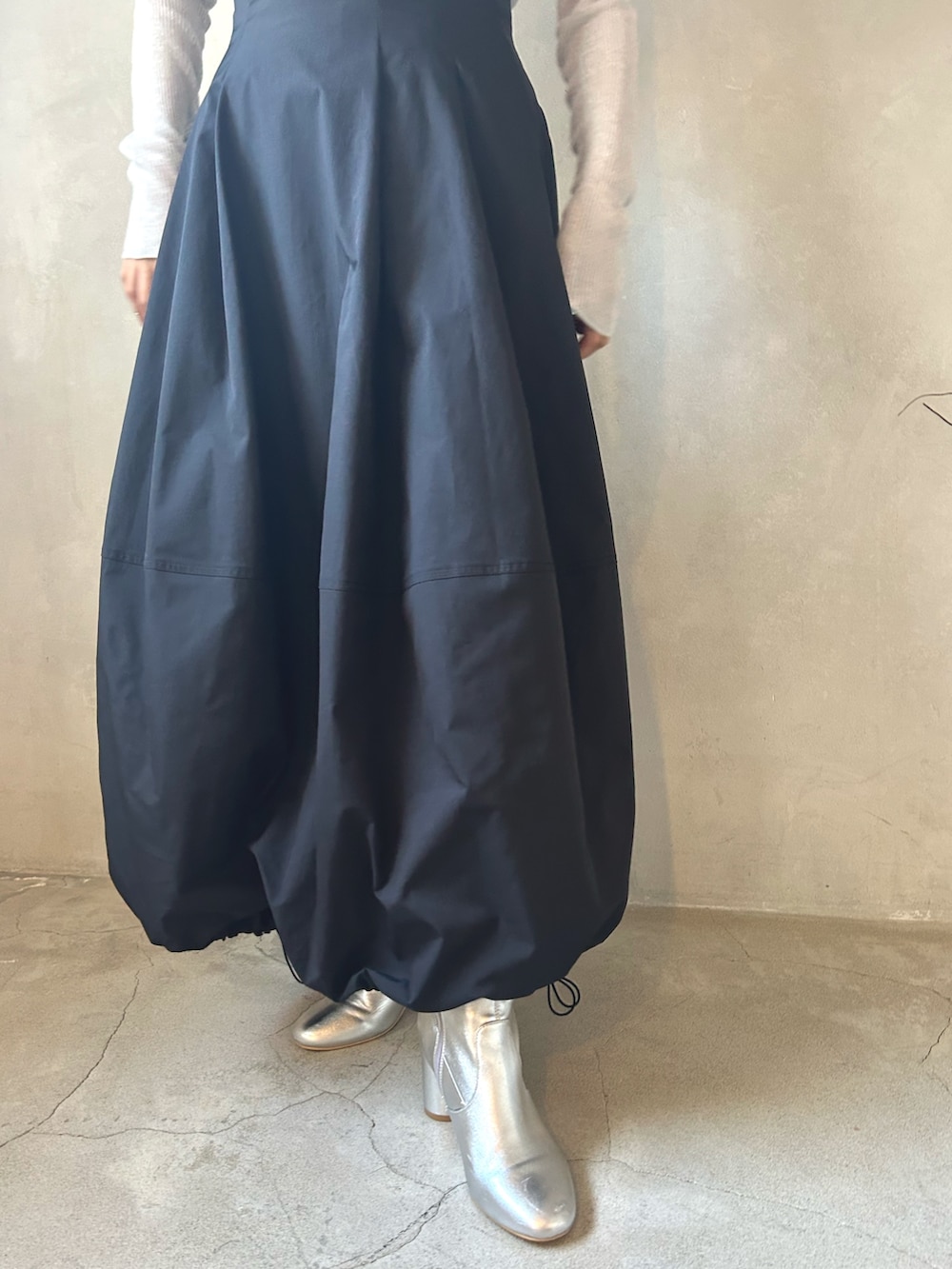 グレー系のニット/セーター、ホワイト系のMA-1、ブラック系のスカートを着用したレディースの春コーディネートの7枚目の写真