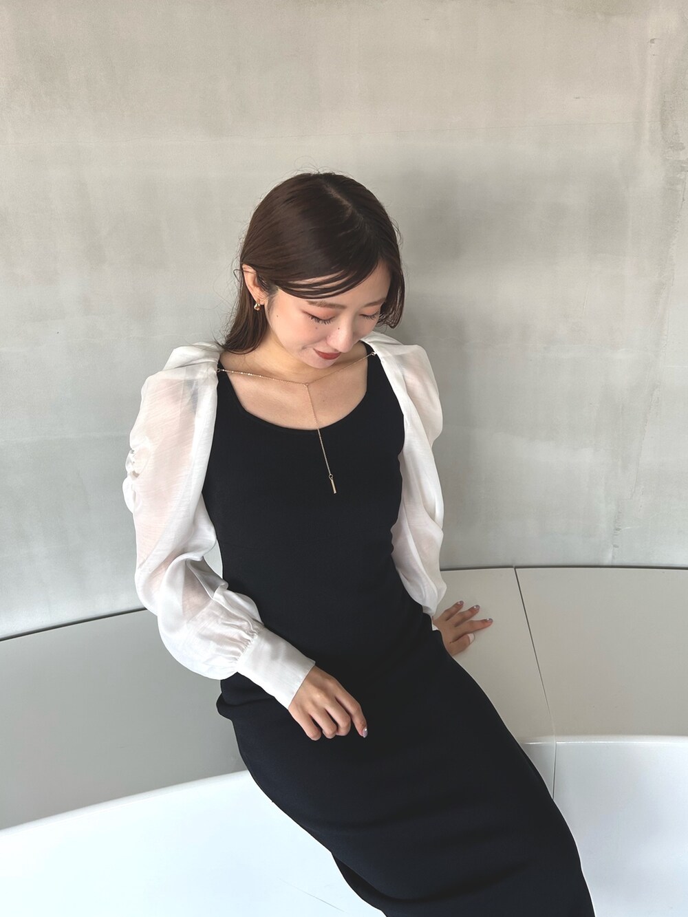 ブラック系のワンピース、ホワイト系のサンダルを着用したレディースの冬コーディネートの9枚目の写真