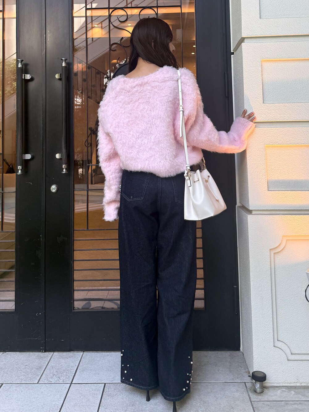 ピンク系のカーディガン/ボレロ、ブルー系のデニムパンツ、ブラック系のパンプスを着用したレディースの秋コーディネートの3枚目の写真