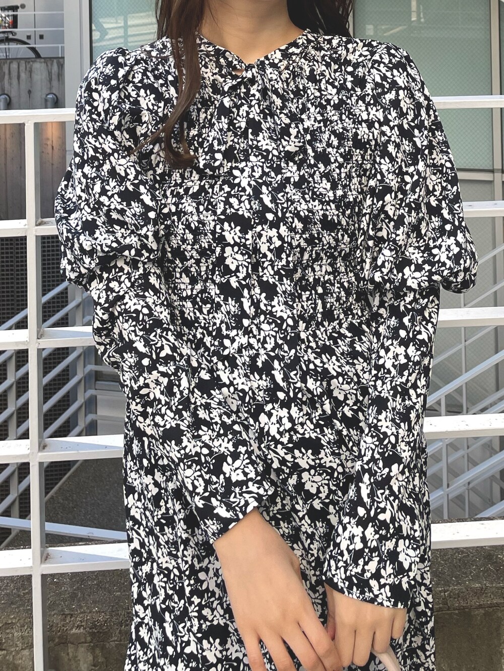 ホワイト系のチェスターコート、ブラック系のワンピース、ブラック系のブーツを着用したレディースの冬コーディネートの5枚目の写真