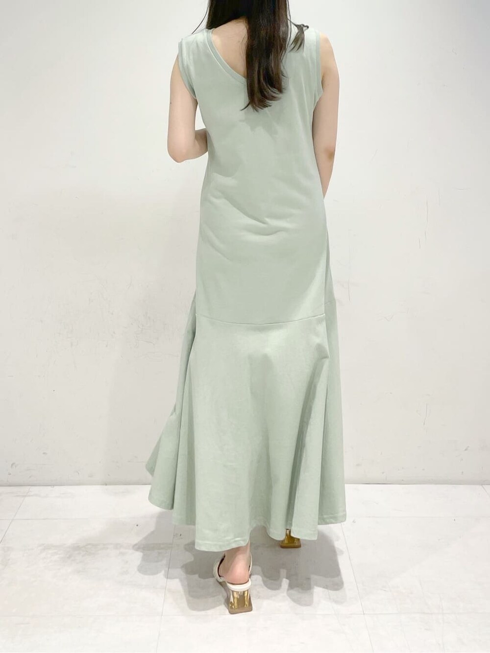 ホワイト系のサンダル、グリーン系のワンピースを着用したレディースの夏コーディネートの4枚目の写真