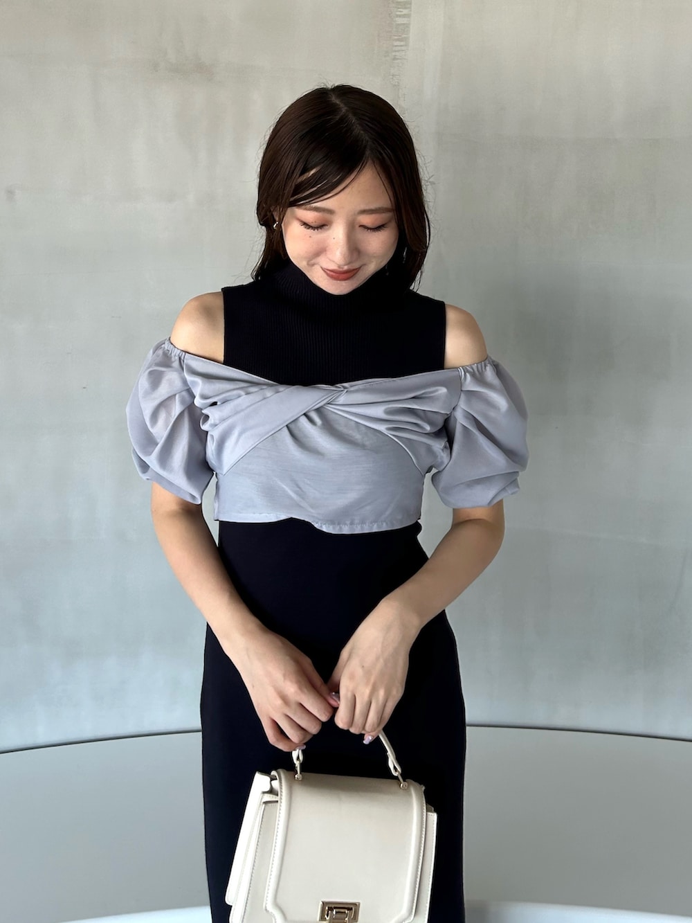 ブルー系のワンピース、ホワイト系のハンドバッグ、ホワイト系のブーツを着用したレディースの冬コーディネートの7枚目の写真