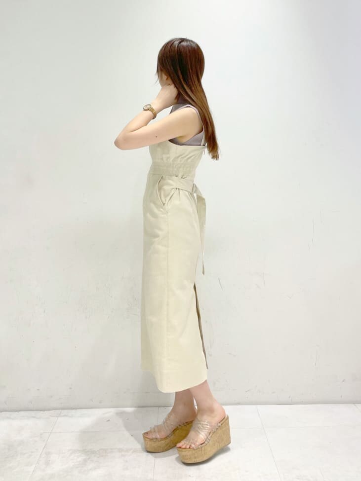 ホワイト系のジャンパースカート、グレー系のニット/セーターを着用したレディースの春コーディネートの2枚目の写真