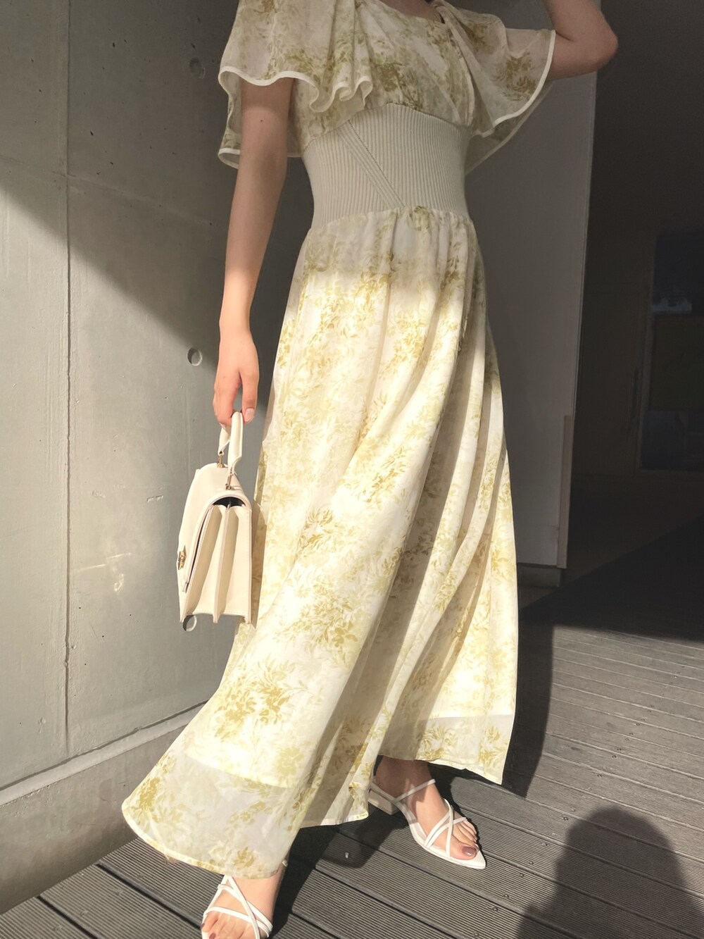 ホワイト系のハンドバッグ、イエロー系のワンピース、ホワイト系のサンダルを着用したレディースの春コーディネートの7枚目の写真