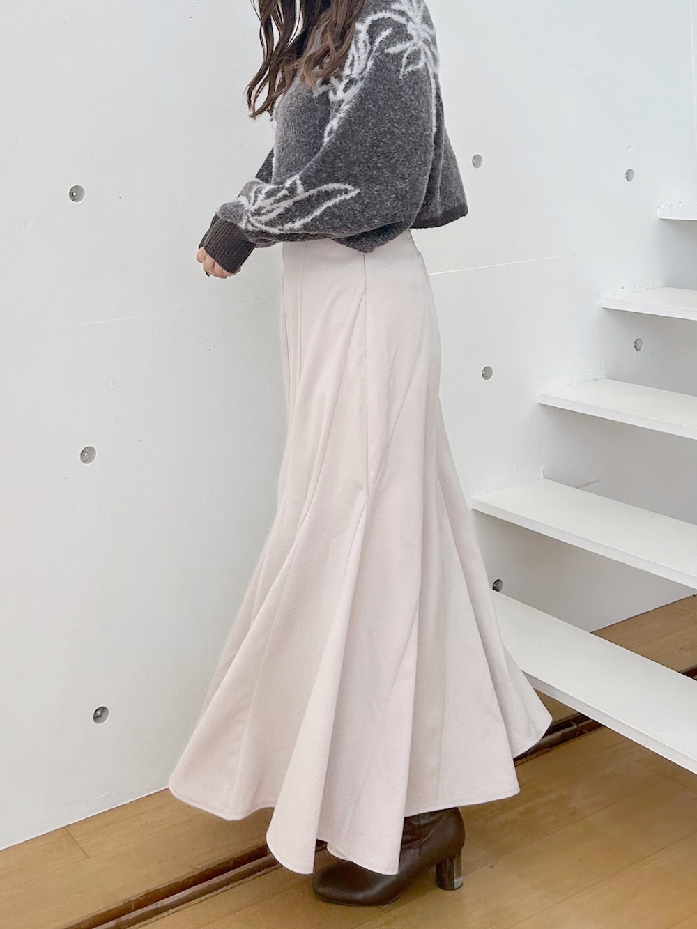 ベージュ系のスカート、グレー系のニット/セーターを着用したレディースの夏コーディネートの2枚目の写真