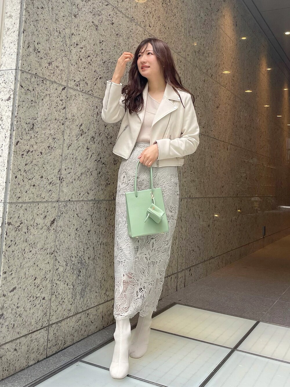 グリーン系のトートバッグ、ベージュ系のニット/セーターを着用したレディースの冬コーディネートの4枚目の写真