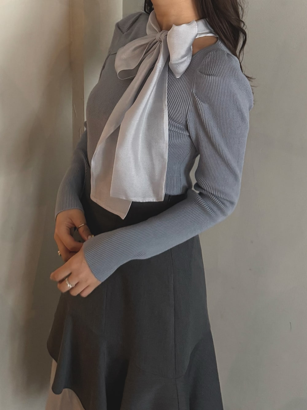 ブルー系のニット/セーター、グレー系のスカート、ブラック系のブーツを着用したレディースの秋コーディネートの4枚目の写真